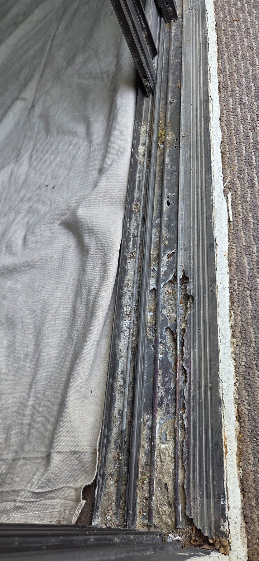 Severely corroded and damaged sliding door track before repair
